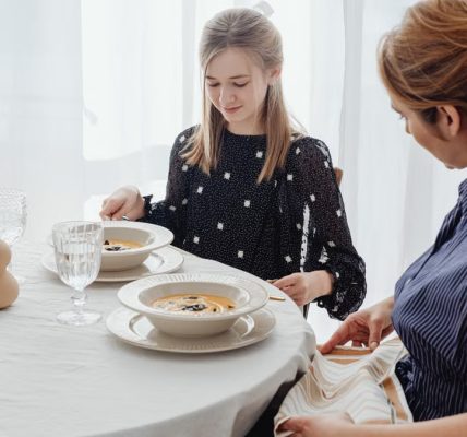 A serene scene of a mother and daughter dining together in a bright, cozy setting.